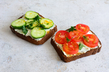 healthy sandwiches with rye bread, soft cheese, tomatoes and cucumbers