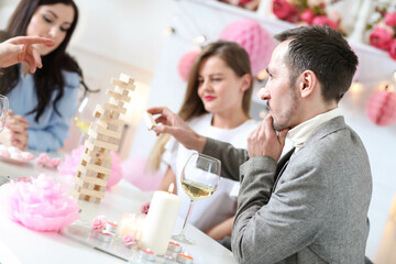 Friends have fun playing games and drinking champagne at the party