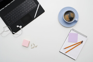 Photo of different office stationary with a cup of dark coffee on a white background