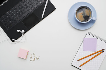 Photo of different office stationary with a cup of dark coffee on a white background
