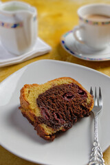 A piece of marble cake with cherries served on a plate. 