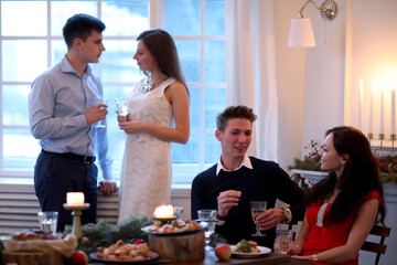 A group of young friends celebrate with many varied food and champagne