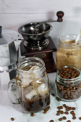Elaboración de café frío con leche, con granos de café recién molidos