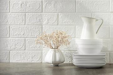 Kitchen utensils and crockery on a shelf or table. White kitchen interior. Free space for text.