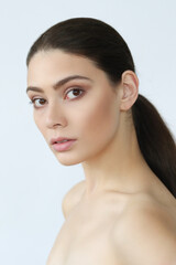 Close-up portrait of a young,beautiful,naked woman standing and looking into the camera on a white background