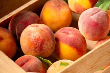 Ripe peaches on basket and wooden background