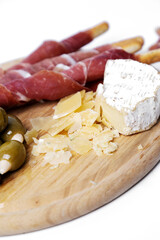Side view of delicious snacks isolated on a wooden cutting board.