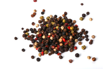 Black, red, white, and green peppercorns on a white background. 