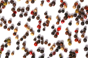 Black, red, white, and green peppercorns on a white background. 