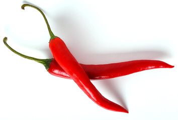 Two fresh juicy red hot chili peppers isolated on a white background.