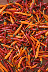 Fresh juicy red and yellow hot chili peppers isolated on a wooden background.