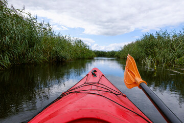 Kayaker point of view. Kayak bow with a view on the river and rushes.   River kayaking concept....