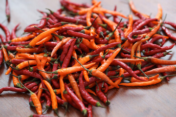 Fresh juicy red and yellow hot chili peppers isolated on a wooden background.