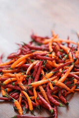 Fresh juicy red and yellow hot chili peppers isolated on a wooden background.