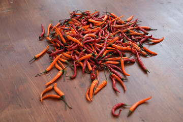 Fresh juicy red and yellow hot chili peppers isolated on a wooden background.