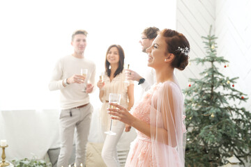 Woman in pink dress holding a glass of champagne at a party.