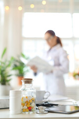 Blurred photo of a woman-doctor standing and working with medication history record forms in...