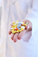 Many tablets of various medicinal drugs in the hand