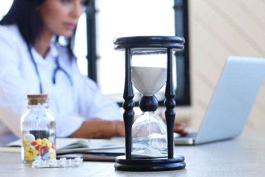 Confident, professional female-doctor sitting and working with medication history record forms at doctor's office