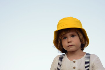 Portrait of a cute boy in a yellow panama hat. A cute child rejoices in the summer. Concept: travel to the resort, holidays with children, kindergarten, holiday, birthday.