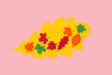 yellow oak leaf with colorful leaves on it, creative art autumn design, pink background
