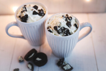 Top view of chocolate frappe coffee with whipped cream and oreo biscuits on wooden background