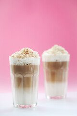 Close view of a tasty caramel milkshake on a pink background.