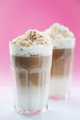 Close view of a tasty caramel milkshake on a pink background.