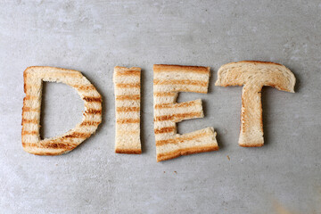 Diet word from toasted bread isolated on a gray background.