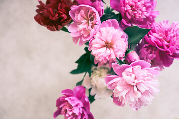 A beautiful bouquet of bright pink peonies. A close-up view of a bouquet of beautiful flowers from above. Wallpaper, greeting card, poster, flower shop concept. High quality photo