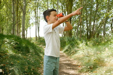 child observes birds with binoculars in the wild. birdwatching in childhood - obrazy, fototapety, plakaty