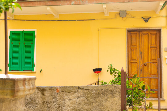 yellow home with green shutters in europe