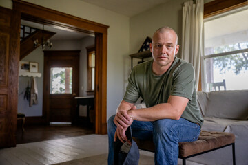 Marine veteran at home with family poses for portrait. - obrazy, fototapety, plakaty