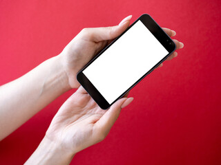 Mobile mockup. Online education. Digital technology. Female hands holding smartphone with blank screen isolated red.