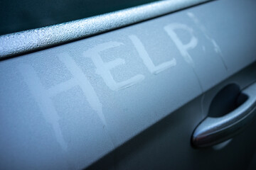 The inscription help on the metal surface of the car in dew drops. Write on the misted surface for help.