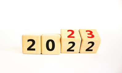 2023 happy new year symbol. Wooden cubes symbolize the change from 2022 to the new year 2023. Beautiful white table white background. Copy space. Business and 2023 happy new year concept.