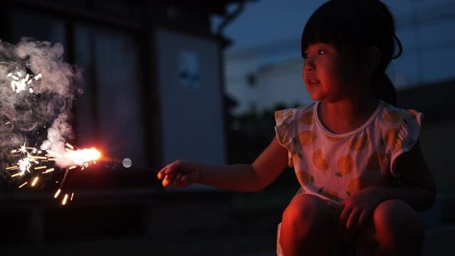 夏休みに家の庭で花火をしている女の子