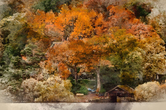 Digital watercolour painting of Stunning landscape image of boat house on Derwentwater in Lake District in colorful Autumn forest setting