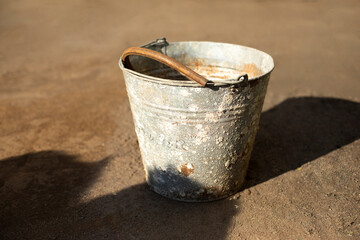 Old bucket outside. Rusty object. Spoiled metal.