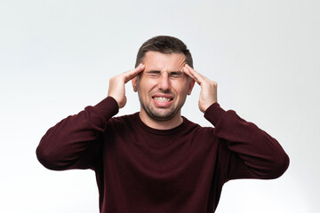 Naklejka premium Handsome man wearing casual sweater feeling tired and headache, Stress and headache concept.