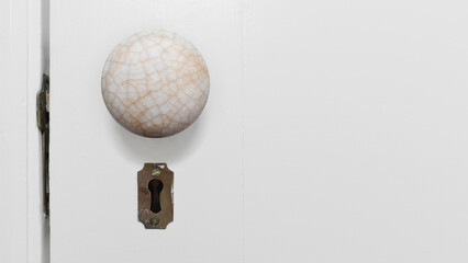 Beautiful close-up color photo of an old antique white crackled porcelain door handle with a...