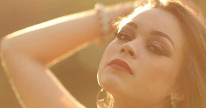 Sensuous young woman in hero 20s posing to camera in outdoor during sunset golden hour time