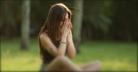Sad depressed girl. Lonely woman alone upset sitting in park outdoors , person having troubles, anxiety and stressed out