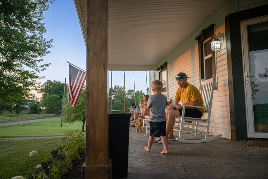 Marine veteran at home with family during sunset on front porch.