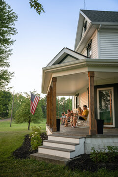 Marine veteran at home with family during sunset on front porch.