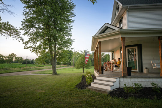Marine veteran at home with family during sunset on front porch.