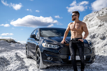 Shirtless muscular man with car. Naked fit macho with sexy torso.