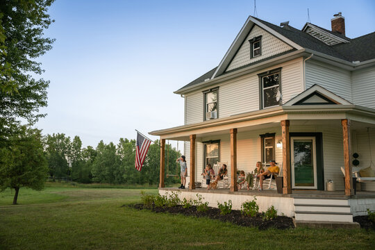Marine veteran at home with family during sunset on front porch.