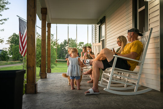 Marine veteran at home with family during sunset on front porch.