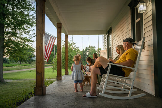 Marine veteran at home with family during sunset on front porch.